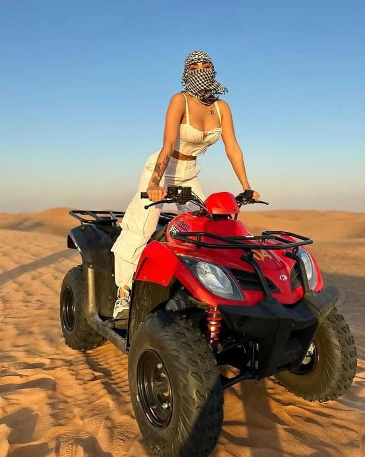 A girl Standing on a single seat ATV Quad Bike